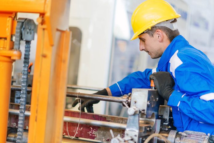 Quality control in packaging production factory - maintenance engineer checking production line machines