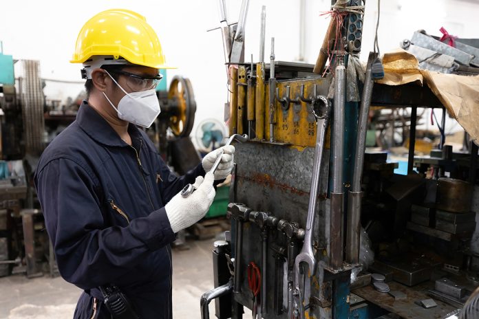 engineer worker or mechanic searching and choosing for the right tool, wearing face mask for protect virus, new normal concept